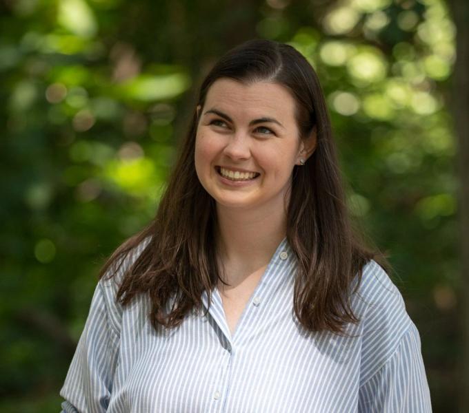 white woman with dark hair smiling away from the camera